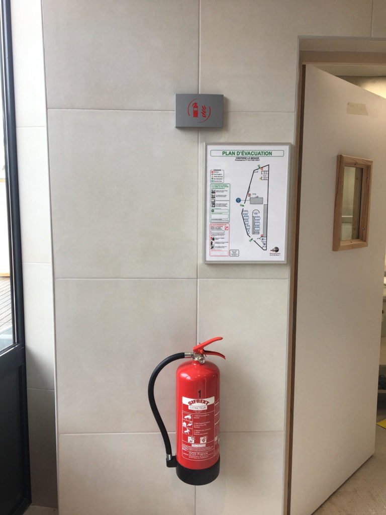 Extincteur installé avec signalétique et plan d’évacuation